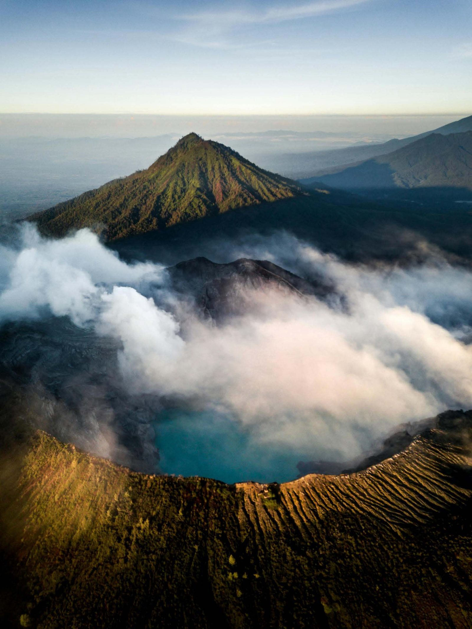 Volcanic crater lake and steam at sunrise