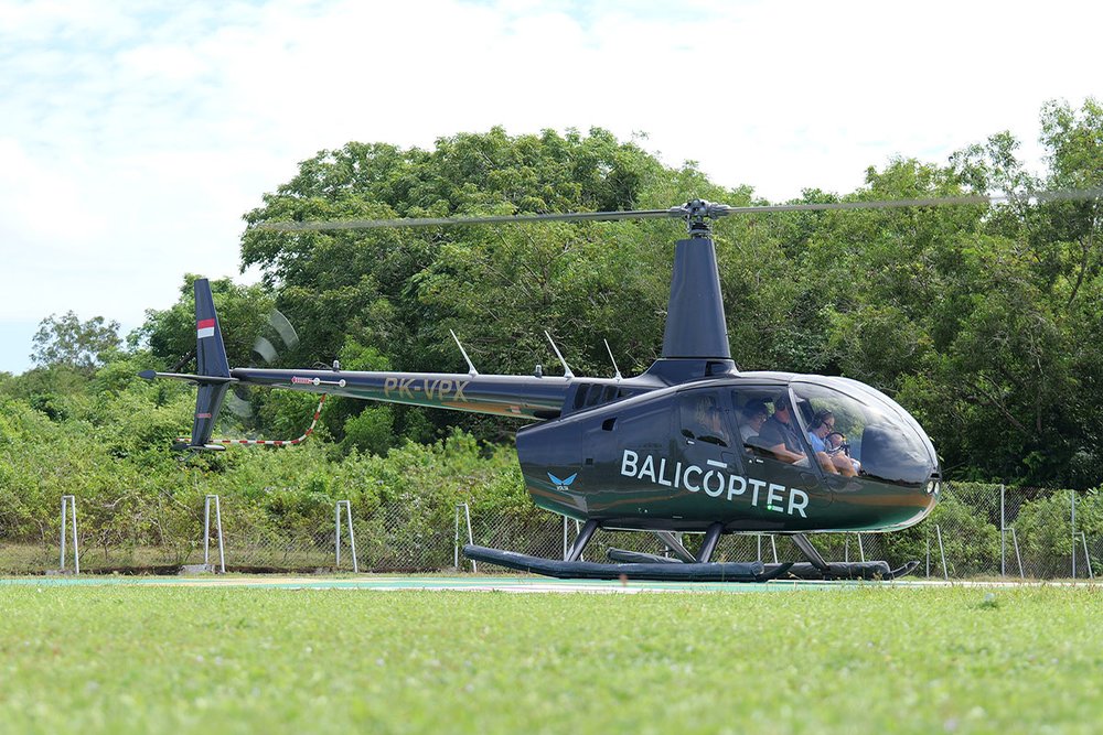 The helicopter on a grass landing area with guests aboard